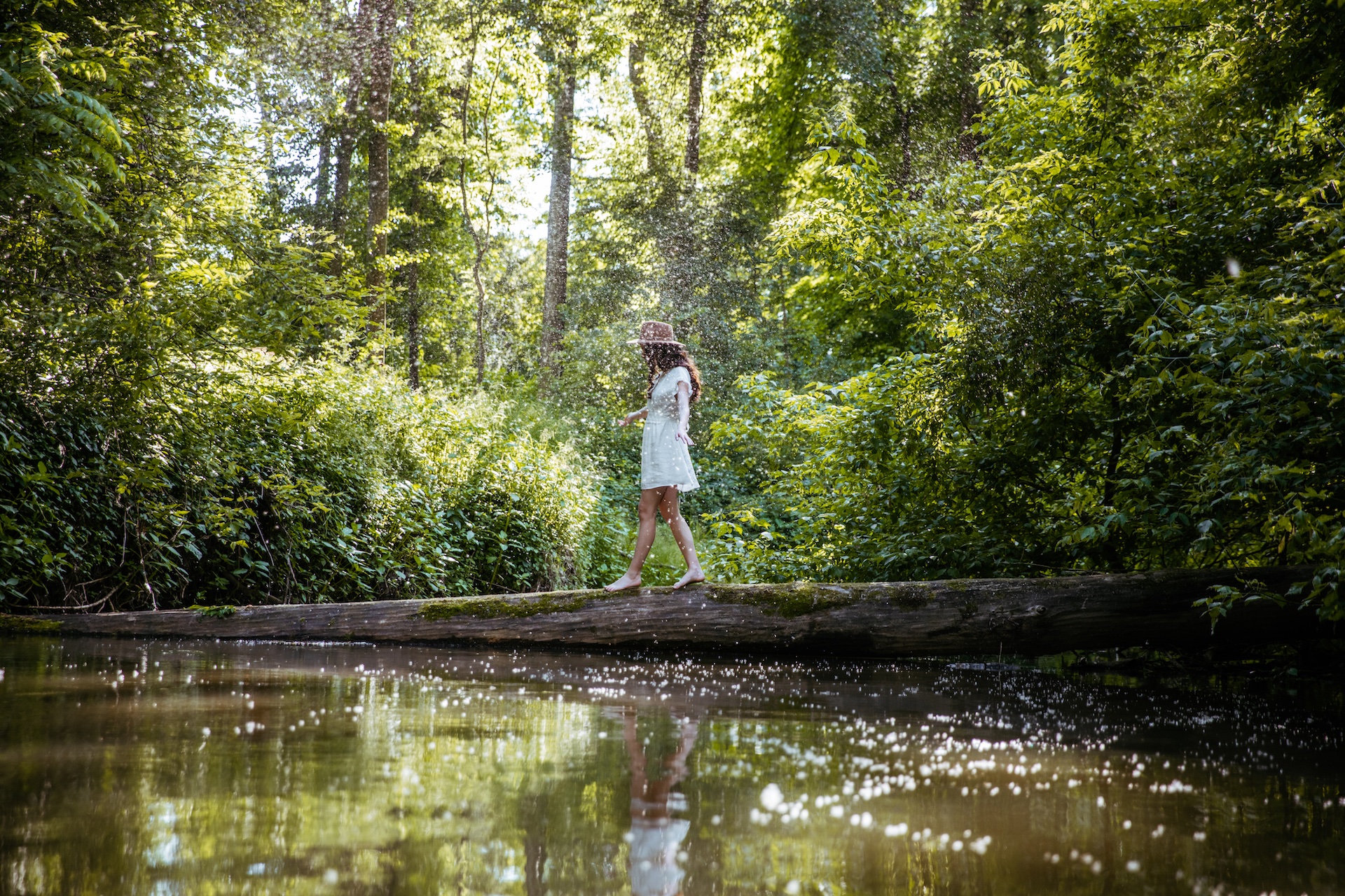 Woman walking on fallen tree trunk